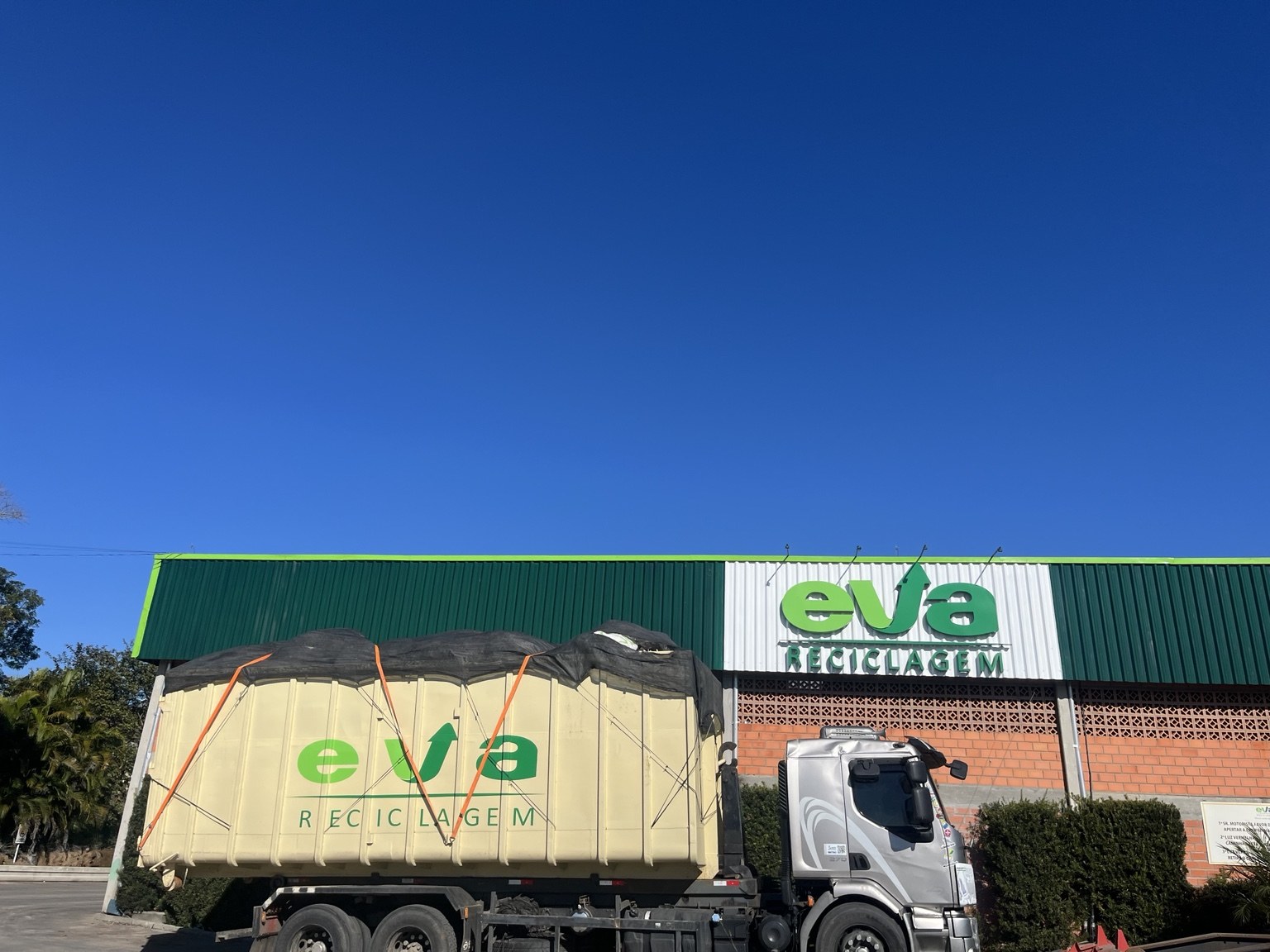 Caminhão da EVA com caçamba em frente à empresa